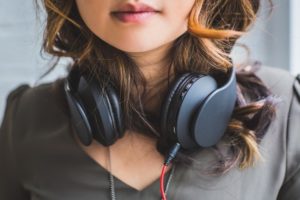 young girl with headphones on neck
