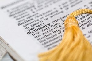 gold tassel lying on english dictionary