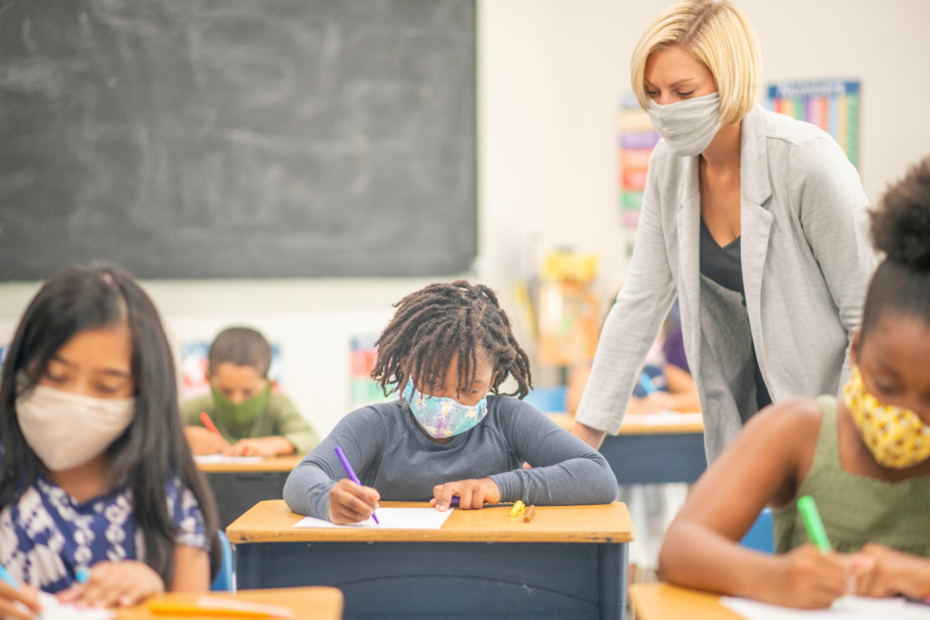 teacher with students in classroom wearing masks due to Covid